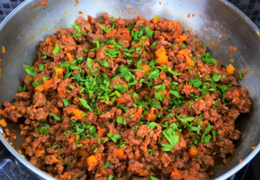 A close up image of meat filling with fresh chopped parsley sprinkled over it