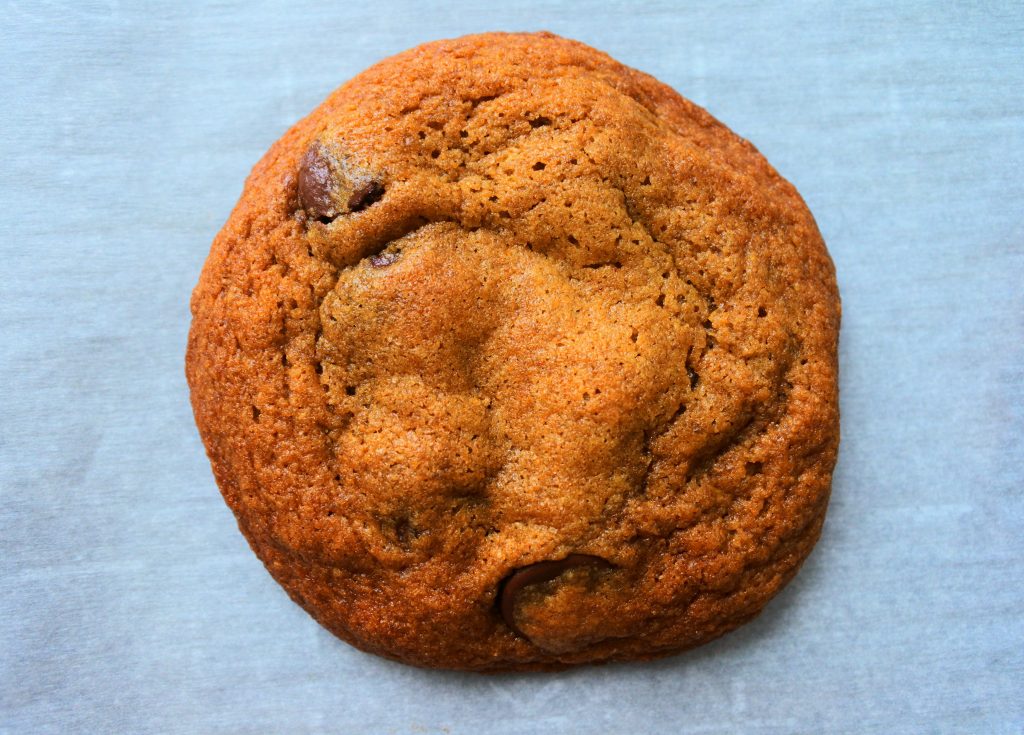 A close up overhead image of a baked classic chocolate chip cookie