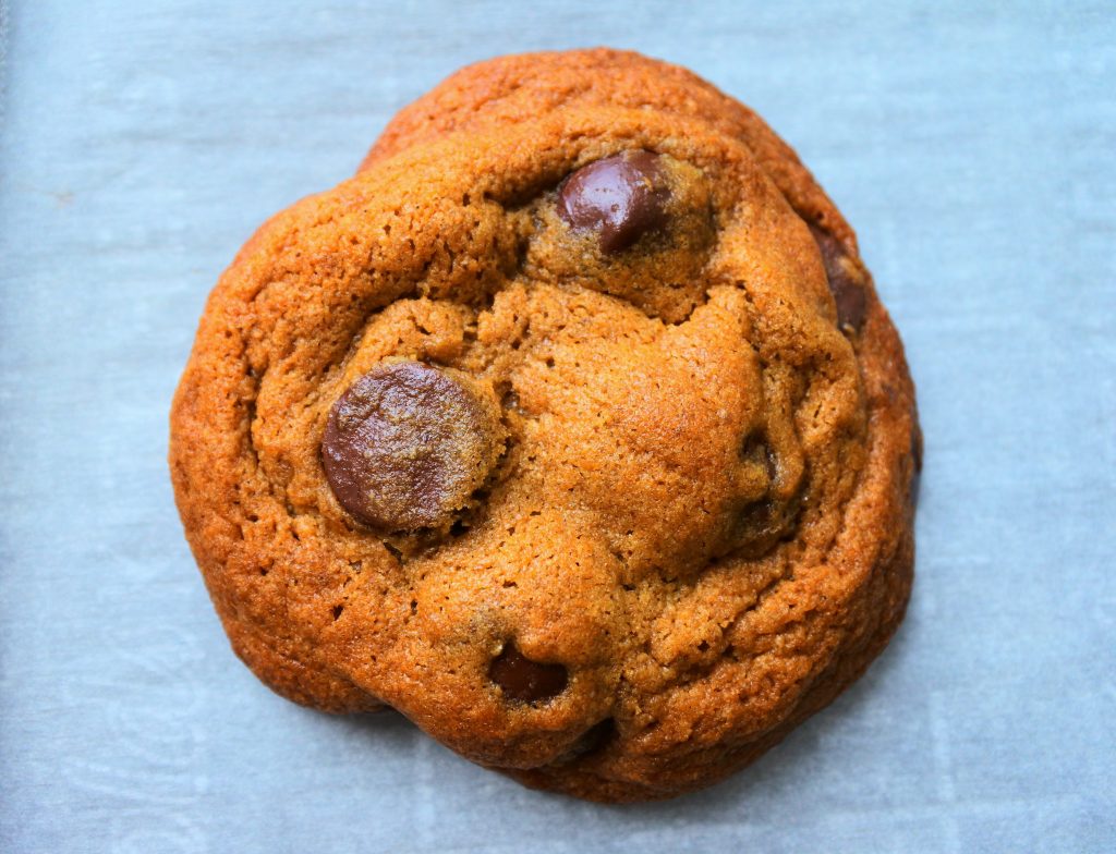 A close up overhead image of a baked classic chocolate chip cookie