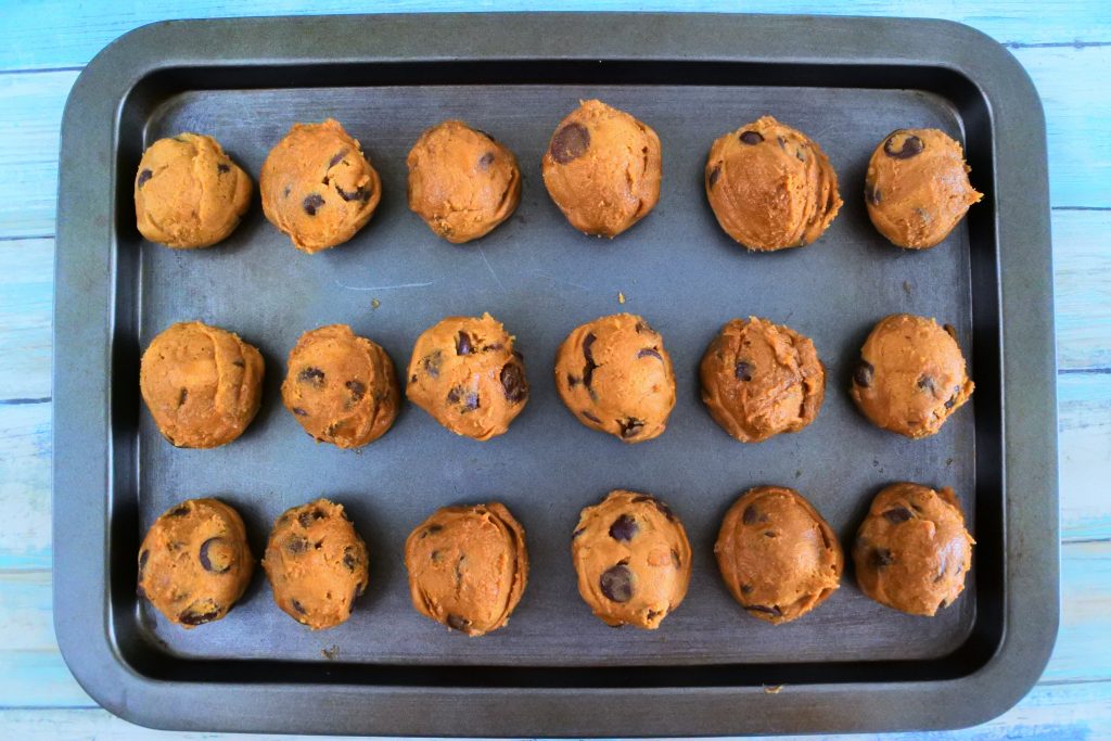 An overhead image of a tray of portioned out chocolate chip cookie dough