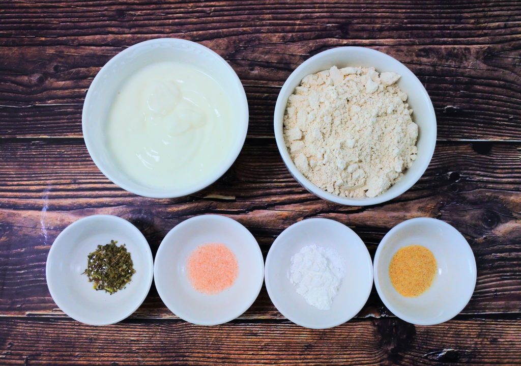 An overhead image of bowls of ingredients for making an easy whole wheat flatbread
