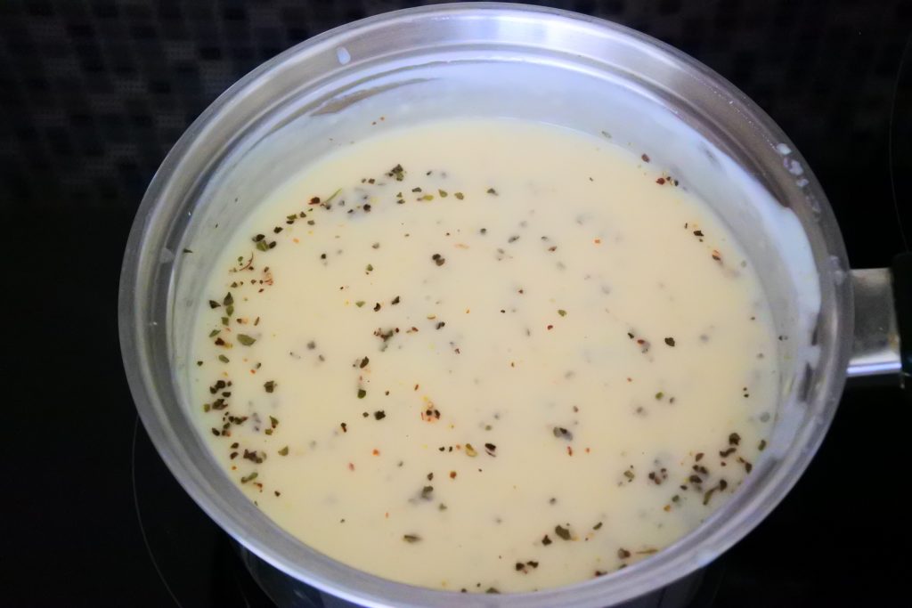 An angled image of homemade Alfredo sauce in a pot