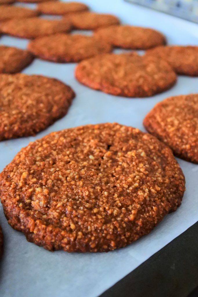 A close up image of baked gingersnap cookies on a tray