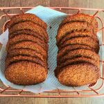 An overhead image of two rows of gingersnap cookies in a paper-lined basket