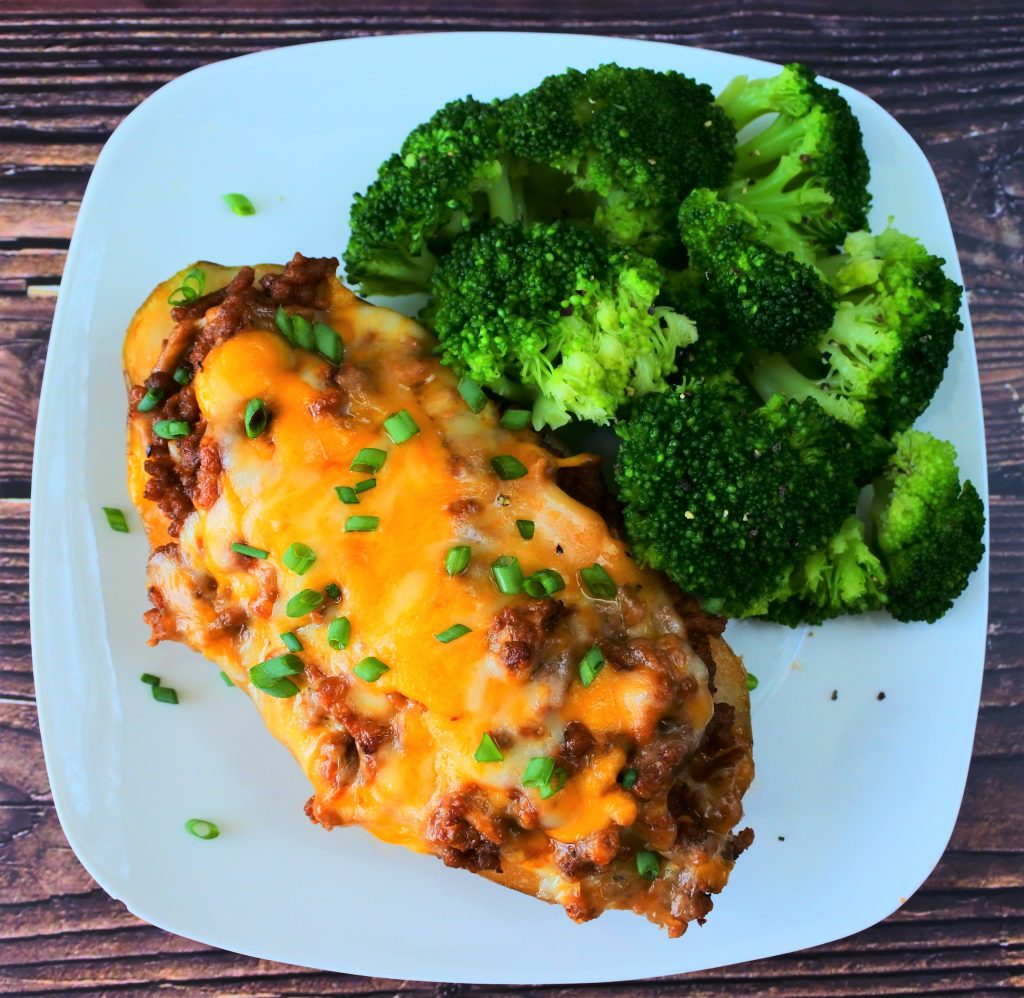 An overhead image of a loaded cheesy meat stuffed baked potato