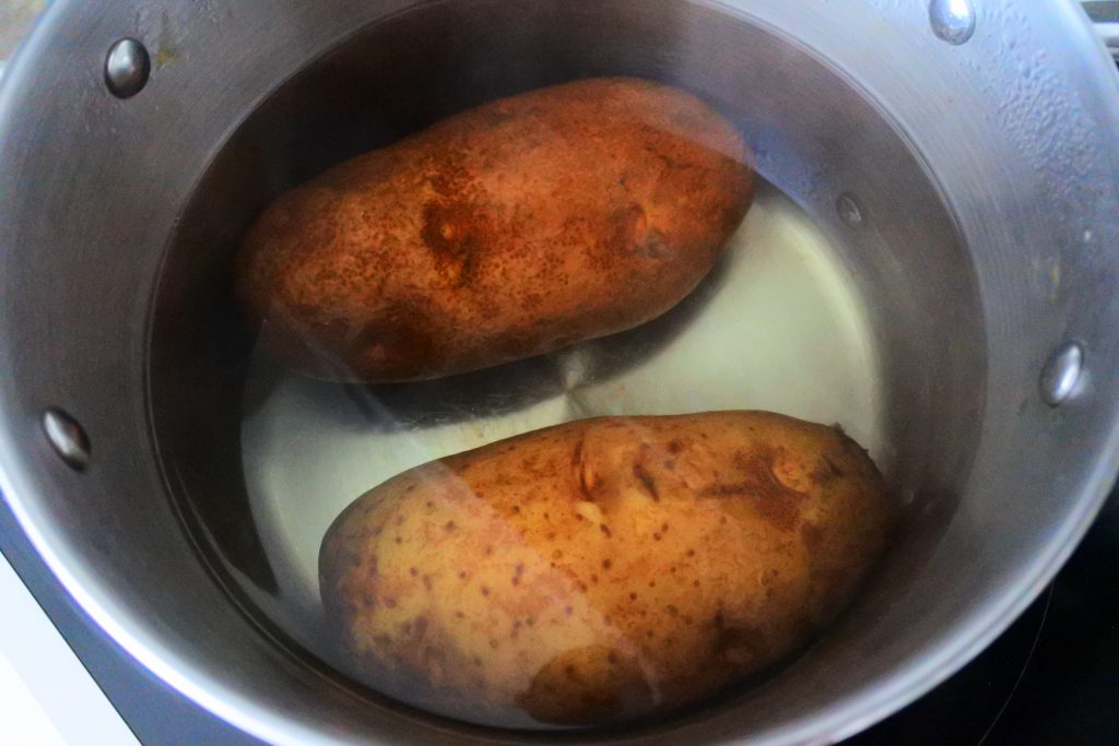 An overhead image of a pot with potatoes in it