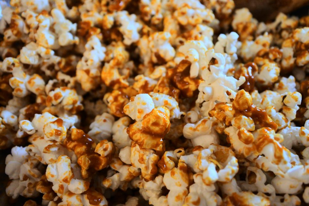 A close up image of caramel popcorn being mixed