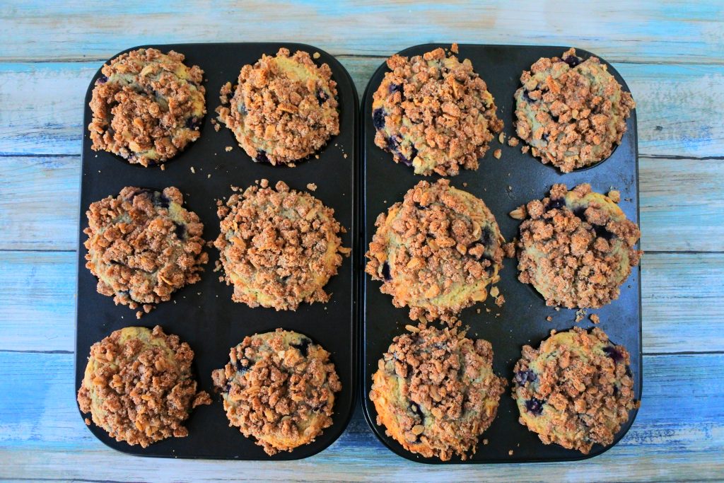 An overhead image of freshly baked blueberry streusel muffins in muffin molds
