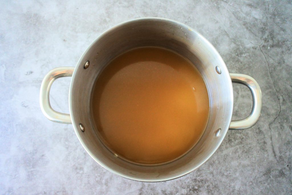 An overhead image of a pot with split peas and broth