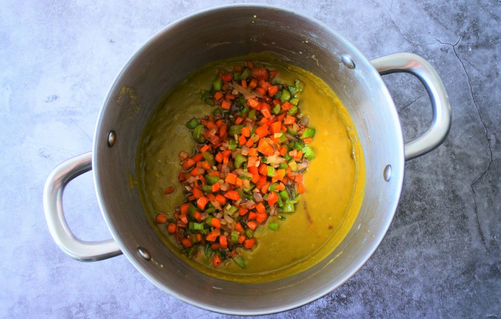 An overhead image of a pot of split pea soup with sautéed vegetables added in