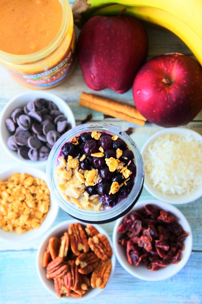 An overhead image of a jar of overnight oats topped with blueberries and surrounded by other potential flavor add ins