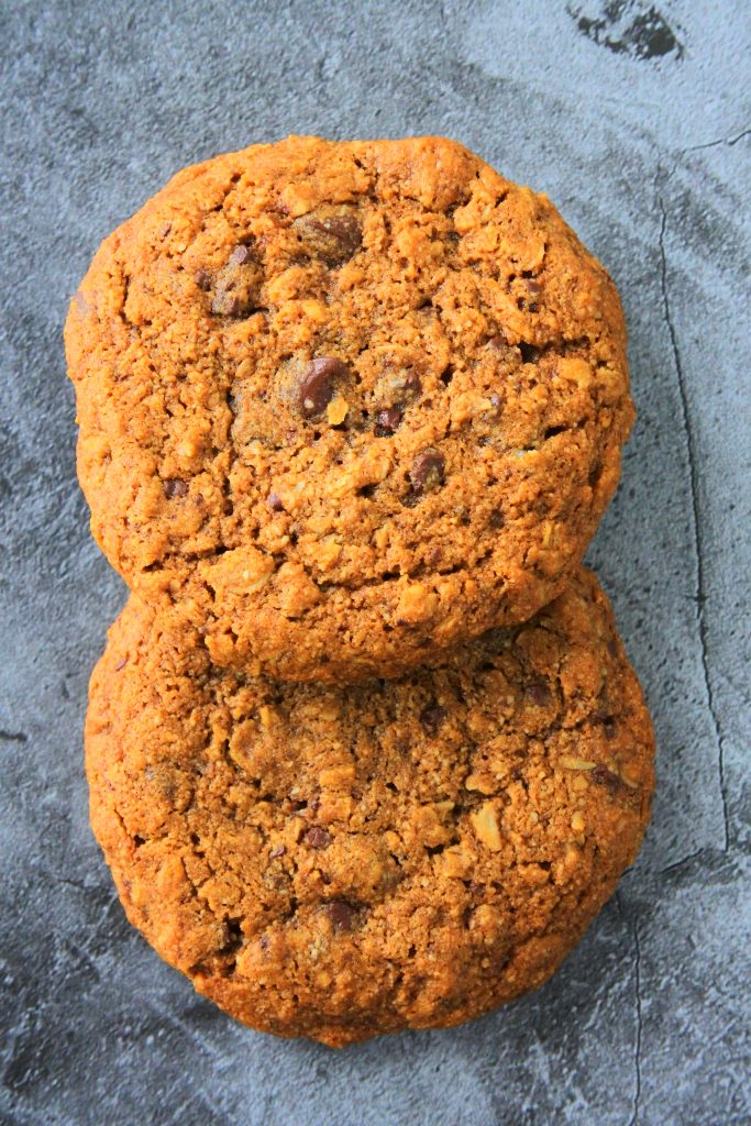 An overhead image of two freshly baked oatmeal chocolate chip cookies