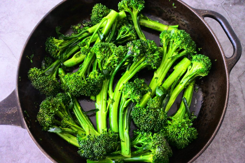An overhead image of a skillet with sautéed broccolini