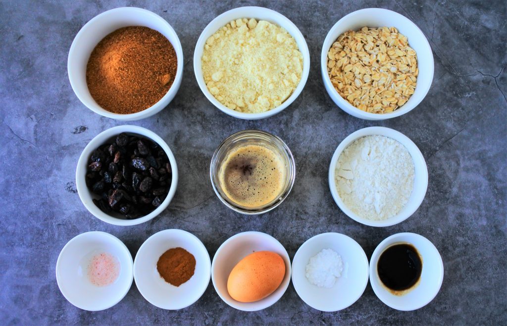 An overhead image of bowls of ingredients for oatmeal raisin cookies