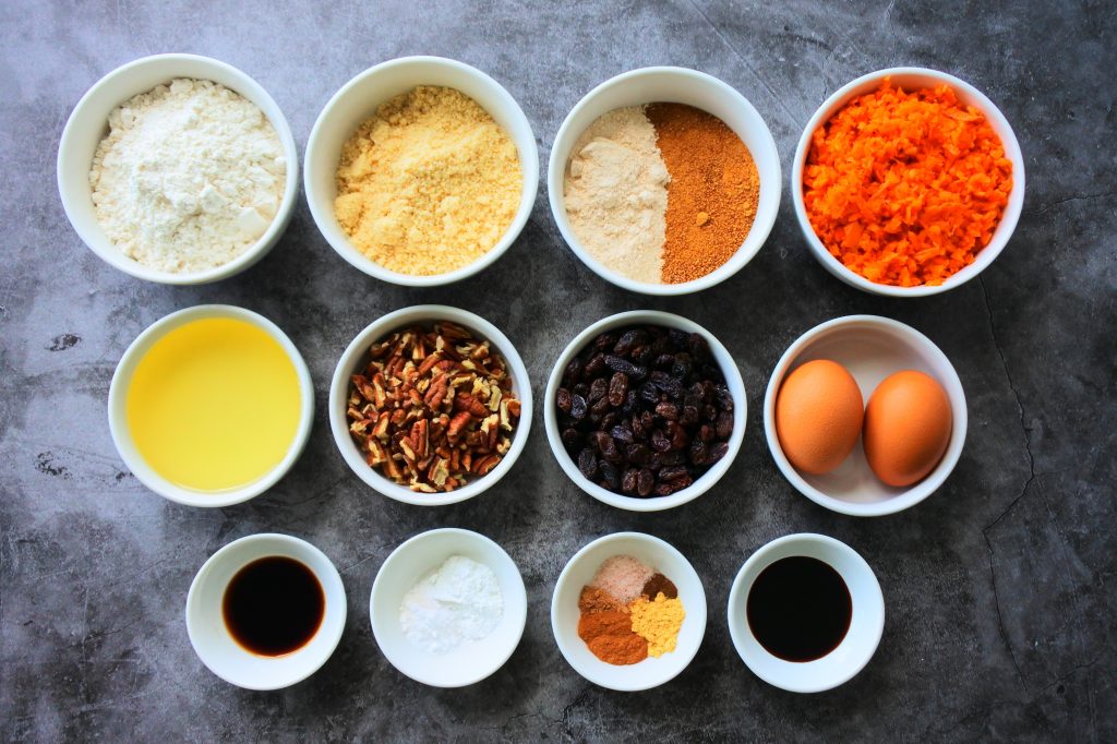 An overhead image of bowls of ingredients for a carrot cake loaf