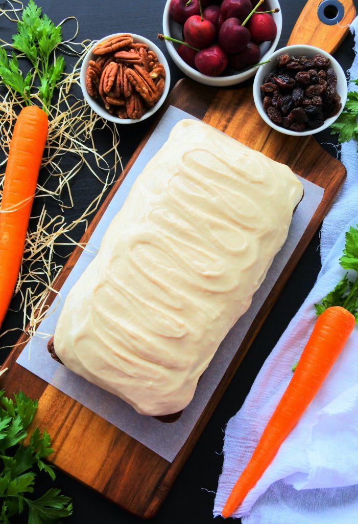 An over head image of a loaf of carrot cake with a Greek yogurt frosting
