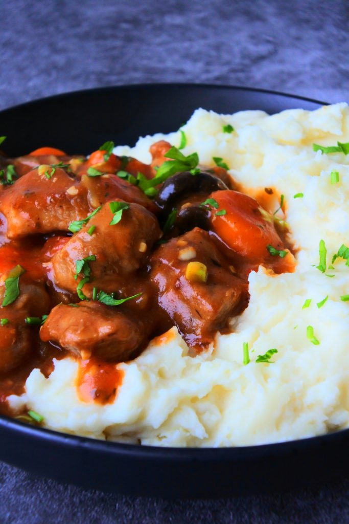 A close up image of spezzatino di manzo - Italian beef stew with a serving of mashed potaotes