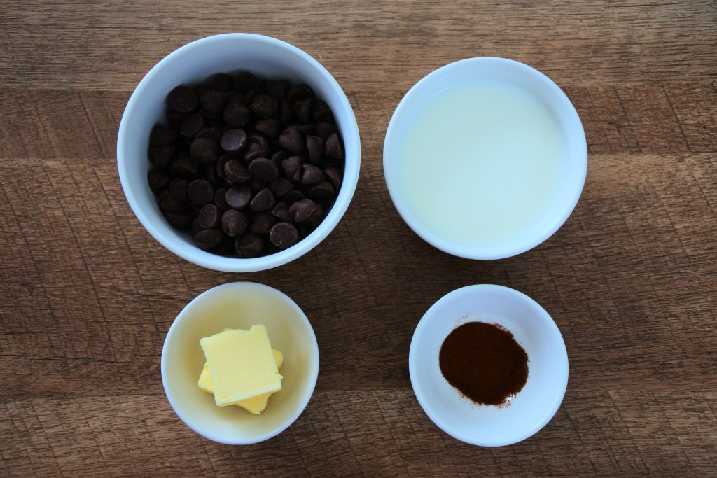 An overhead image of bowls of ingredients for a chocolate ganache frosting