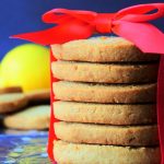 A head on image of a stack of gluten-free lemon shortbread cookies with a red bow wrapped around it
