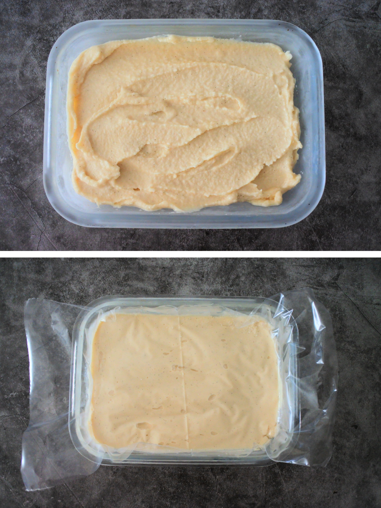 An over head image of freshly made homemade vanilla ice cream scooped into a chilled container with a layer of plastic wrap pressed against the surface before being covered and put to set in the freezer.