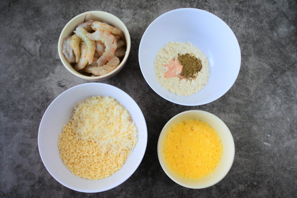 An overhead image of bowls set up to be a breading station for coconut shrimp