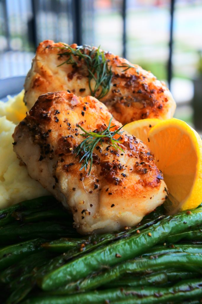 A head on image of pan-fried monkfish fillets over mashed potatoes and green beans