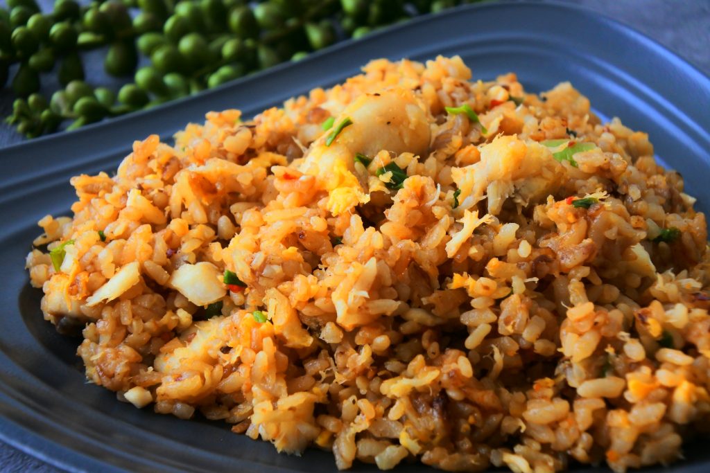 An angled close up image of a plate of crab fried rice.