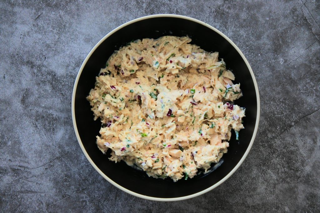 An overhead image of a black bowl of tuna salad