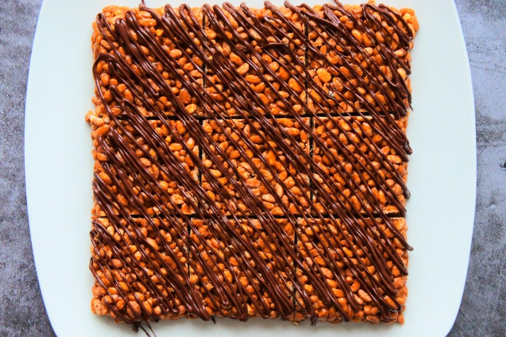 An overhead image of PB Rice Crispy treats drizzled with tempered chocolate