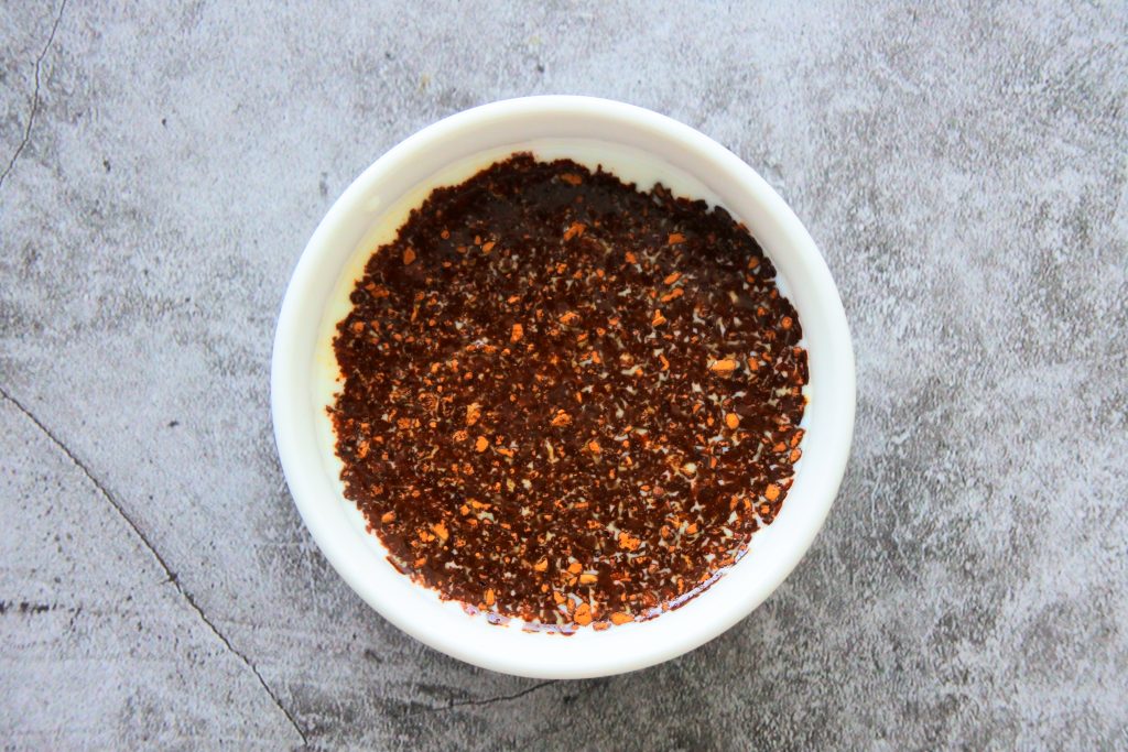 An overhead image of a bowl of milk with instant coffee granules added to it
