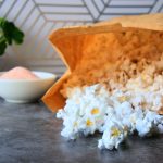 A head on image of a brown paper bag of microwaved popped popcorn