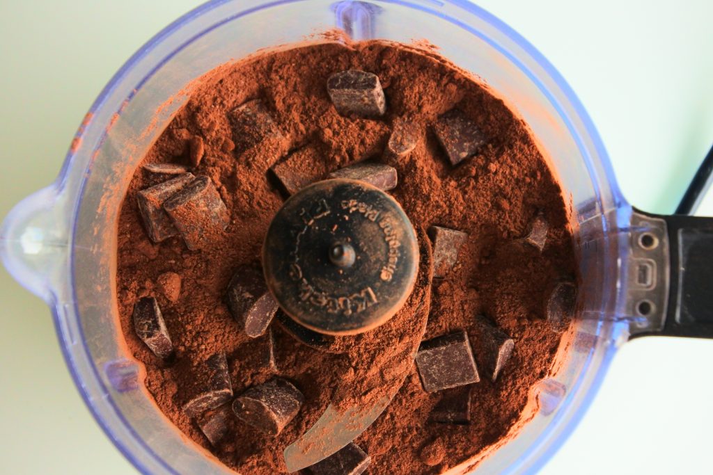 An overhead image of dark chocolate chunks before being blended into a hot cocoa mix in a food processor