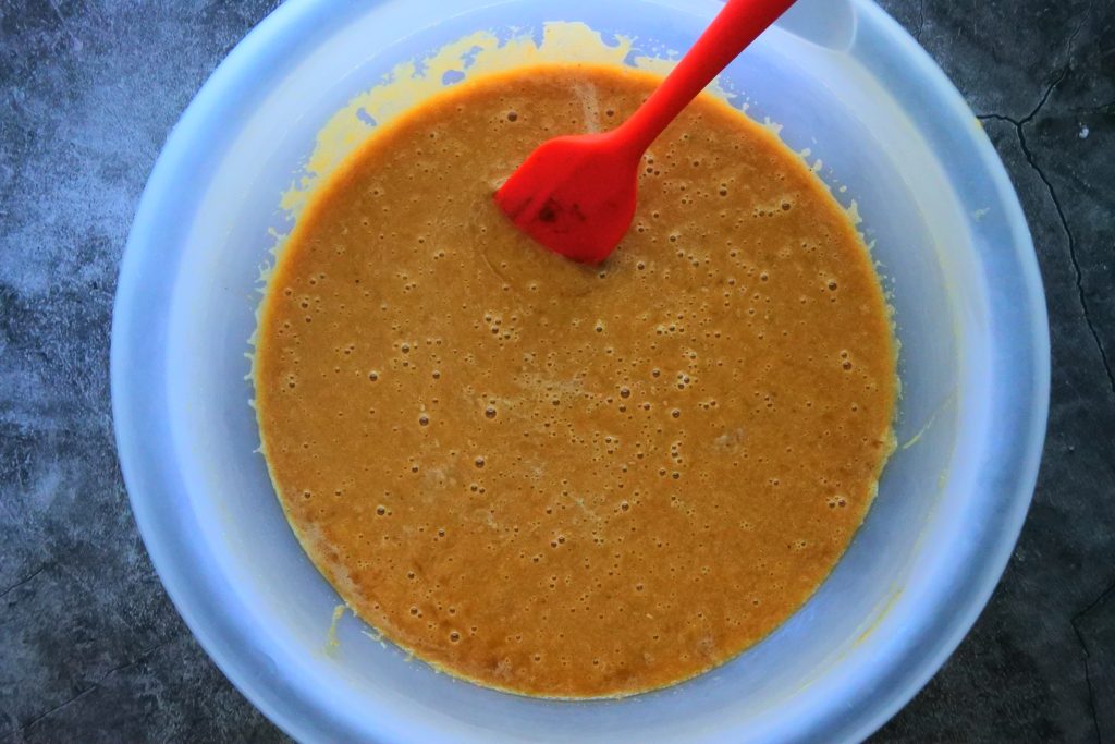 An overhead image of wet ingredients being mixed together to make a gluten-free banana bread batter.