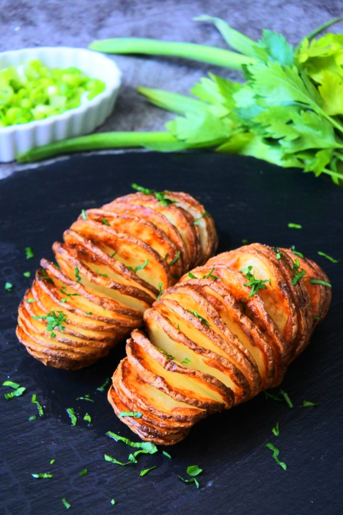 An angled image of crispy air-fried Hasselback potatoes .