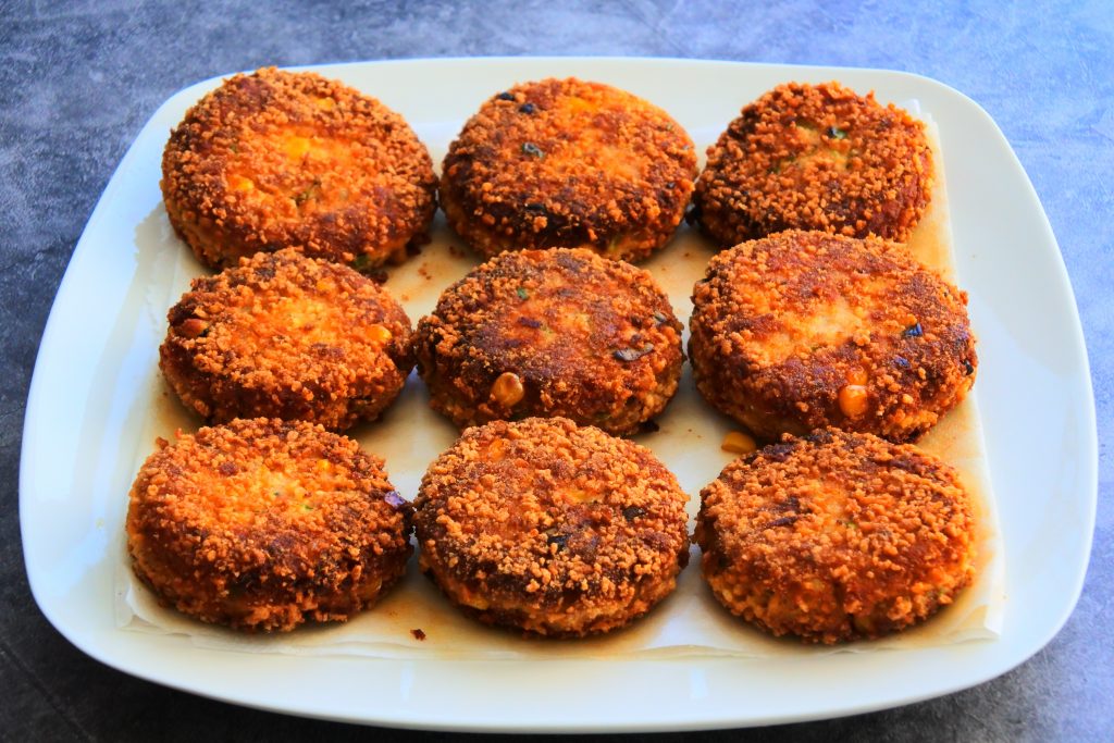 An angled image of a plate of crispy golden brown salmon croquettes on a plate.