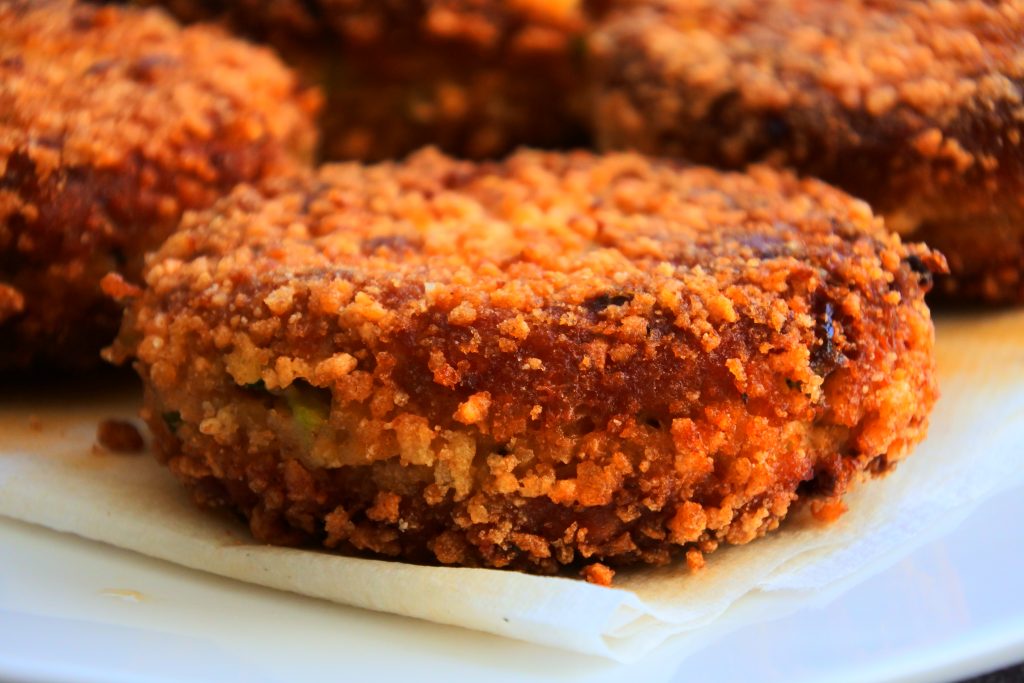 A head on close up image of a crispy golden brown salmon croquette.