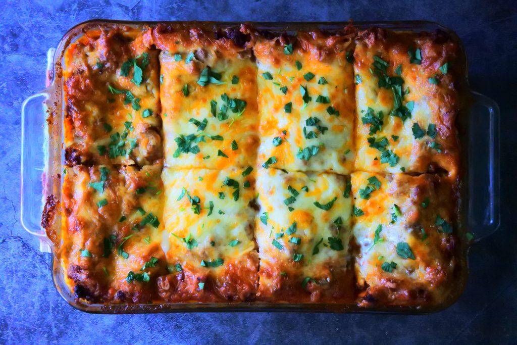An overhead image of a dish of Kitrusy's Gluten free Lasagna after being baked, cooled, cut and topped with fresh parsley