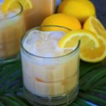 A close up angled image of a glass of Kitrusy's Creamy Dreamy Lemonade served over ice with a lemon wedge on the rim.