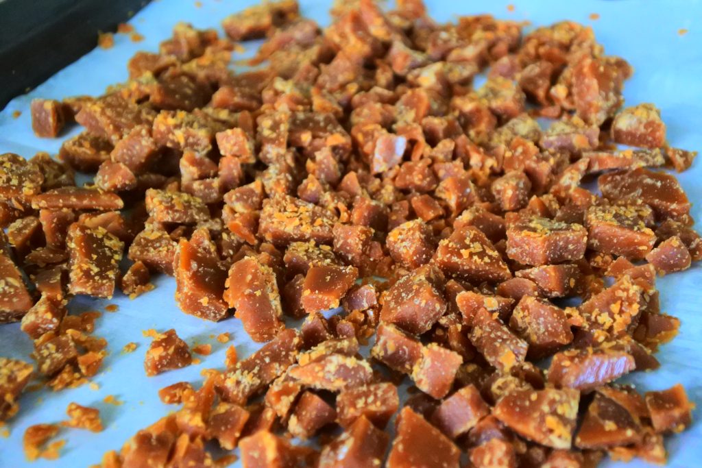 An angled image showing a homemade butterscotch toffee after being shattered into chunks.