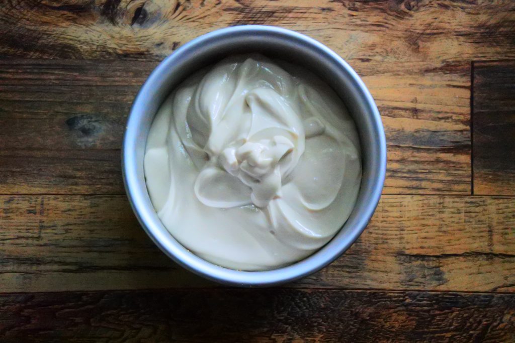 An overhead image showing the filling after being poured over the crust for a gluten-free Greek Yogurt Cheesecake