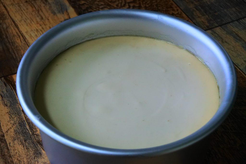 An angled image showing a how the edges of a gluten-free Greek yogurt cheesecake should look after being baked