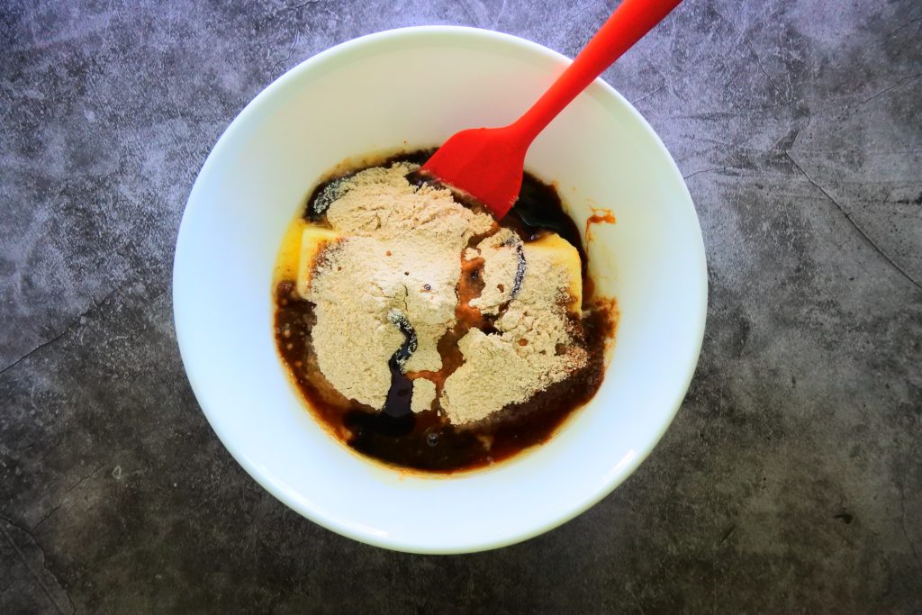 An overhead image of wet ingredients being mixed together for a gluten free gingerbread cookie dough