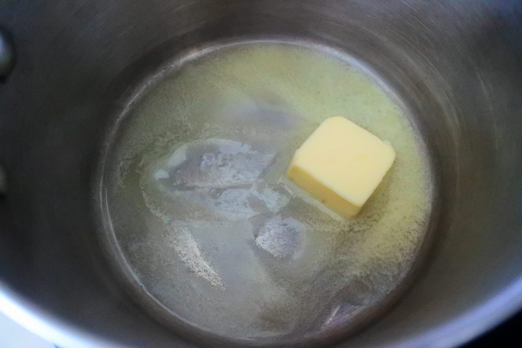 An overhead image of a pot with butter being melted