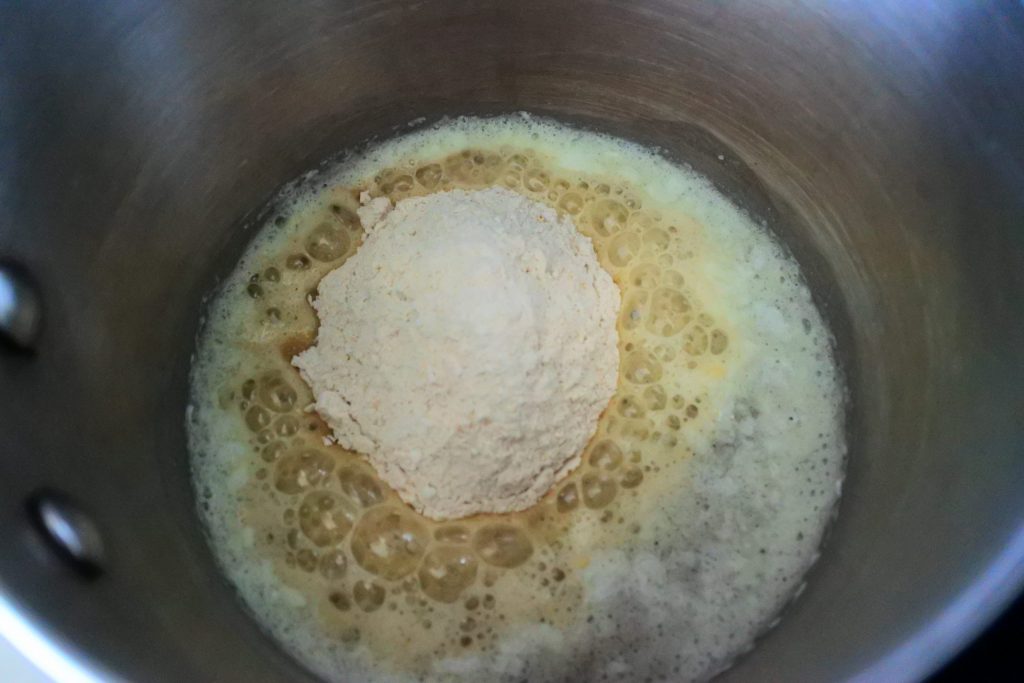 An overhead image of a pot with flour added to melted butter