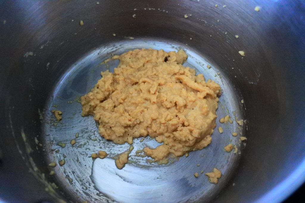 An overhead image of a pot with a butter and flour roux being cooked