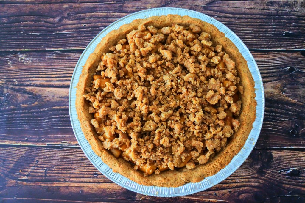 An overhead image of a homemade apple pie topped with a crumb topping
