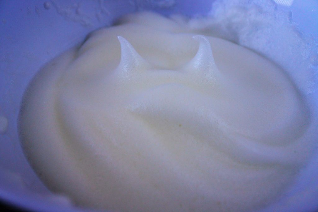 A close up image of whipped egg whites with stiff peaks