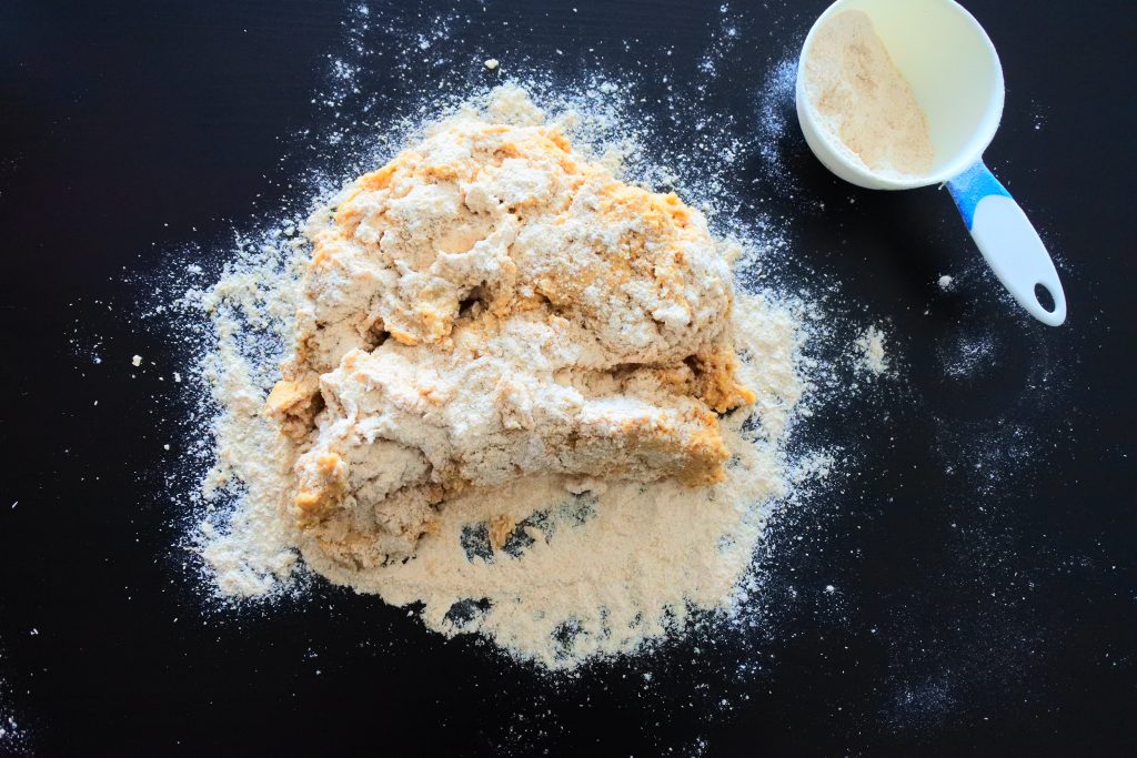 An angled image of floured bread dough on a floured work surface
