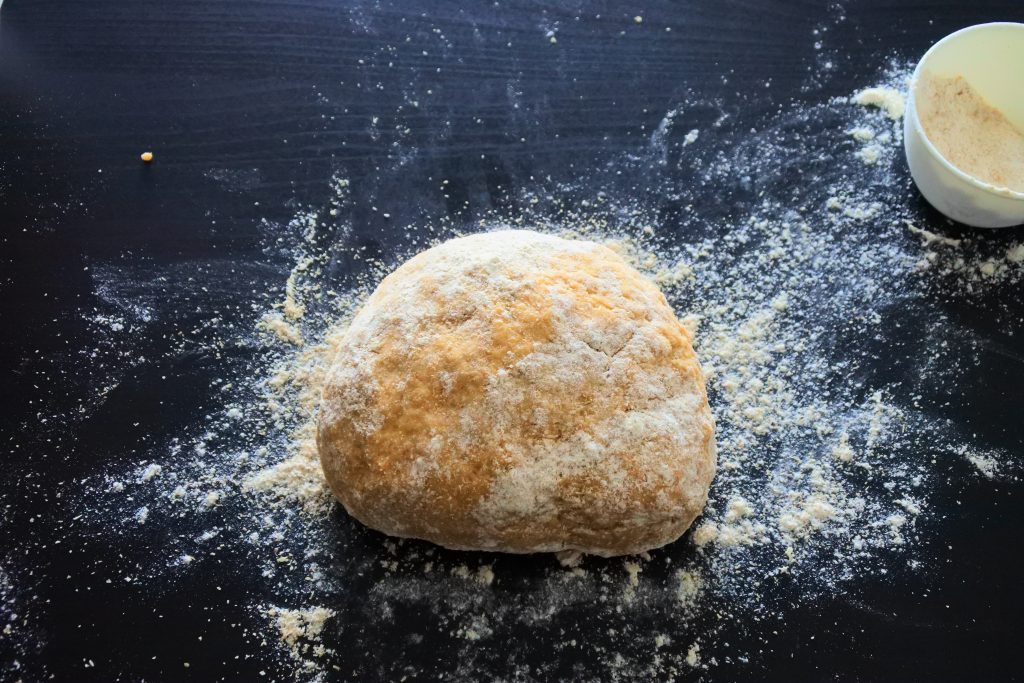 An angled image of floured bread dough on a floured work surface