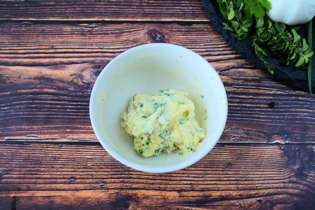 An overhead image of a bowl of herbed butter
